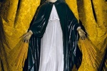 A painted statue of a Madonna with a gold crown of stars standing on a globe and set against a gold brocade canopy from a church in Madrid, Spain. Fine art prints of this photo are available framed in various styles, please inquire.