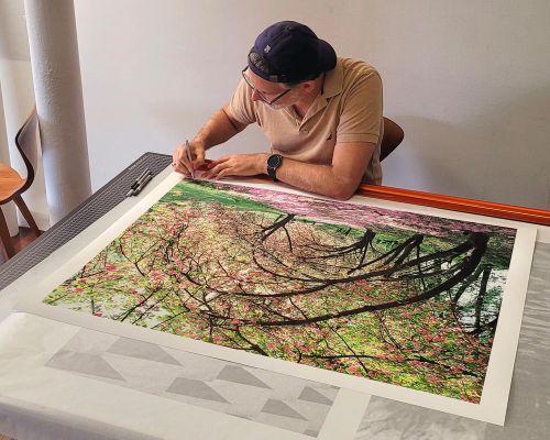 Photographer Andrew Prokos signing a 30x40 inch fine art print of 'Central Park Spring Cherry Blossoms'