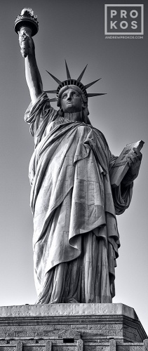 A vertical panoramic view of the Statue of Liberty in black and white, New York City.