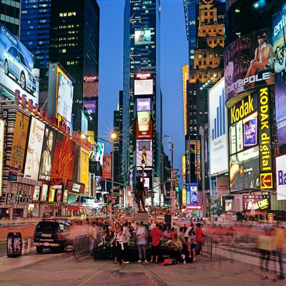 A panoramic cityscape photo of the signs of Times Square at dusk, New York City