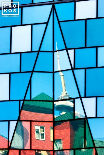 An architectural photo of CN Tower reflected on the glass facade of a Fashion District building, Toronto, Canada
