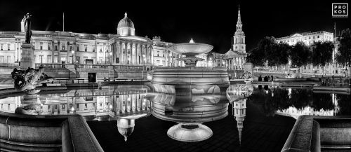A black and white panoramic photo of Trafalgar Square, London at night, United Kingdom. Limited edition prints of this photo are available up to 120 inches in width
