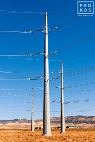 A photo of a group of steel electricity transmission towers set in a sparse Southern Idaho landscape