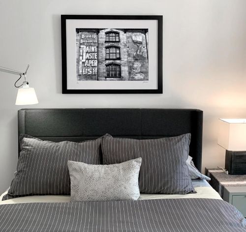 A matted and framed black and white print of 'Tribeca Street Mural' by photographer Andrew Prokos in the NYC residence of a new collector