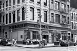 A black and white street scene photo showing the landmark Odeon Restaurant in Tribeca, New York City