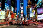 A panoramic cityscape photo of the signs of Times Square at dusk, New York City