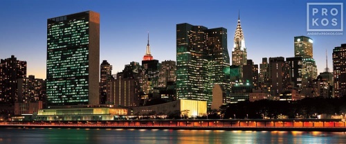 A panoramic cityscape photo of the Midtown Manhattan skyline and the United Nations at dusk, New York City.