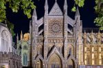 A wide angle view of the ornate gothic facade and rose window of Westminster Abbey's north transept at night, by night photographer Andrew Prokos