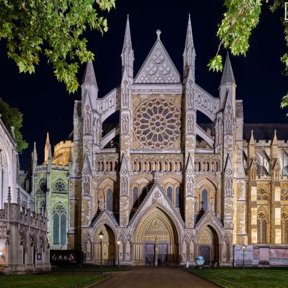 A wide angle view of the ornate gothic facade and rose window of Westminster Abbey's north transept at night, by night photographer Andrew Prokos