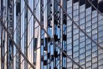 An abstract photo of warped reflections of modern buildings on a black glass facade in London, United Kingdom. High-definition fine art prints are available up to 80 inches.