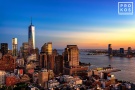 A cityscape photo of Lower Manhattan, World Trade Center, Hudson River, and New Jersey at dusk.
